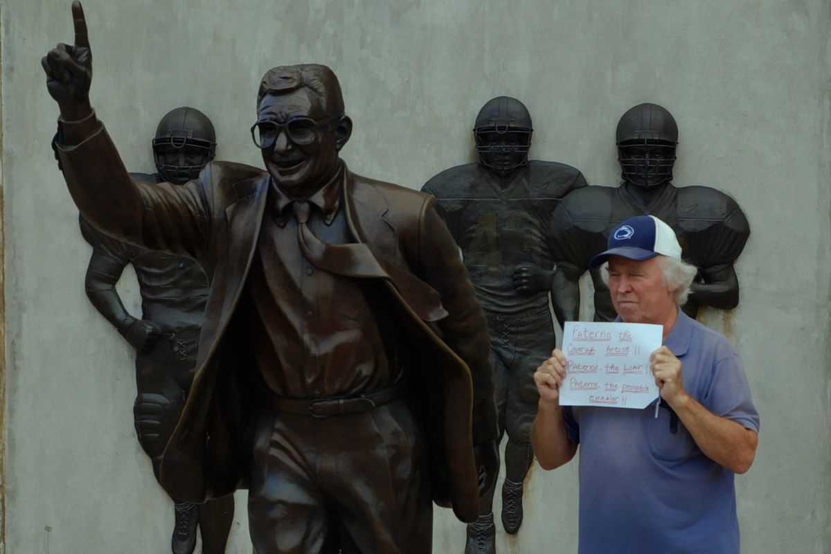 Bernie McCue protests next to the Joe Paterno statue in “Happy Valley.”
