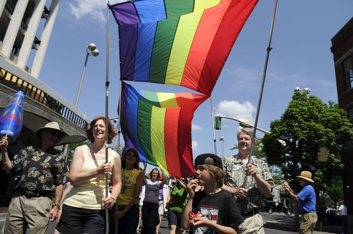 Betsy and Richard Rush support the front of a rainbow flag sponsored by the Unitarian Universalist Church in the annual Pride Parade in downtown Spokane on Saturday. (Jesse Tinsley / The Spokesman-Review)