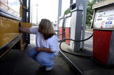 
Coeur d'Alene School District bus driver Jill Hill puts the fuel cap back on a district bus after putting 32 gallons of diesel fuel in it Thursday morning. The cost of fuel has hit school districts hard, sometimes quadrupling costs year to year. 
 (Jesse Tinsley / The Spokesman-Review)