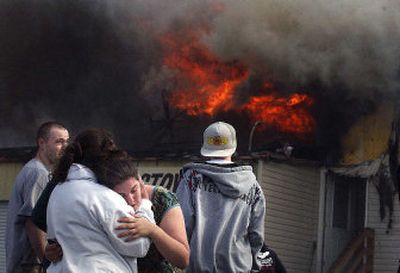 
Amanda Herther is comforted as flames rip through her Post Falls apartment Monday after a fire started in the late afternoon. Herther's apartment at 410 North Greensferry Road is attached to the  Stow and Go Self-Storage facility.
 (Brian Plonka / The Spokesman-Review)