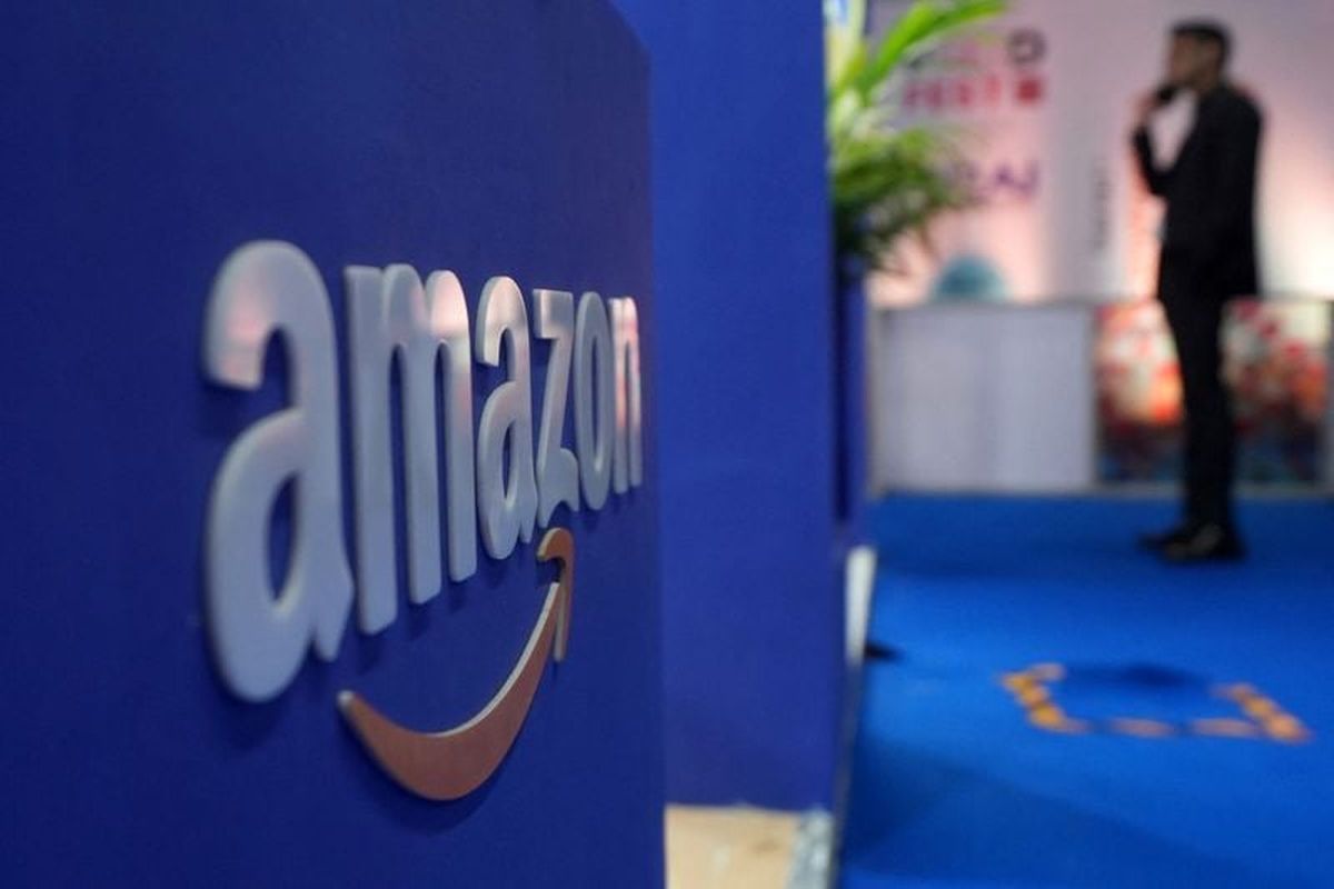 A visitor stands near a logo of Amazon during the annual Retail Leadership Summit in Mumbai, India, February 27.   (Reuters )