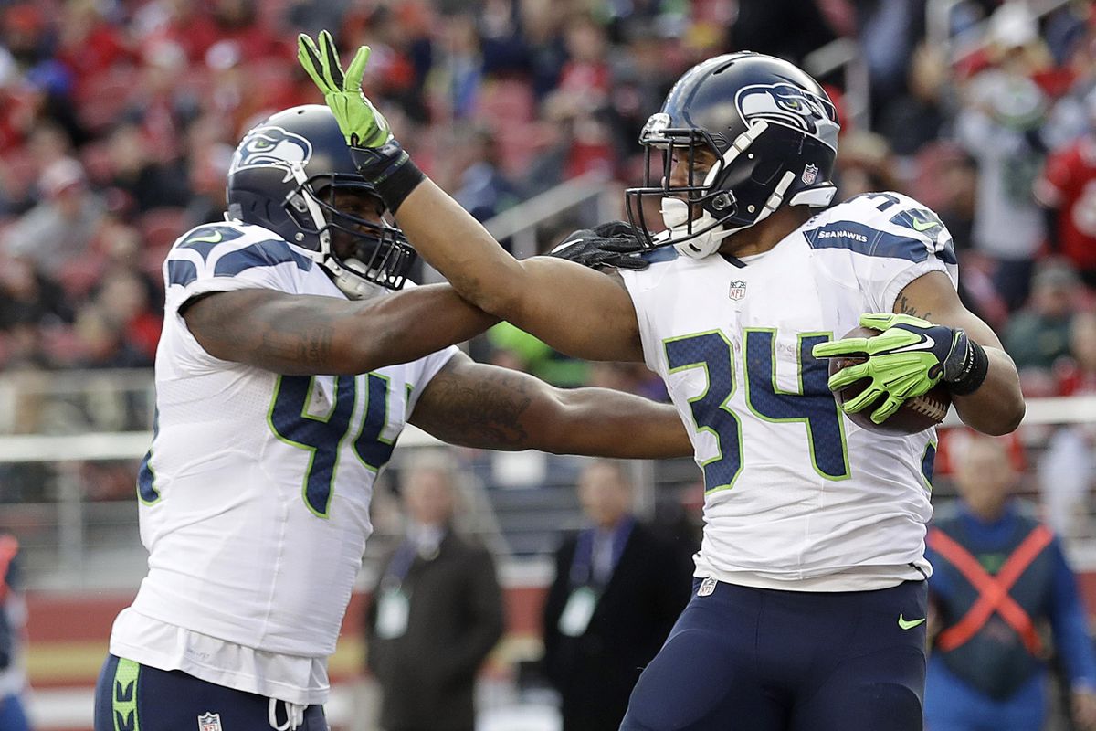 Seattle Seahawks running back Thomas Rawls (34) celebrates with fullback Marcel Reece (44) after scoring a touchdown during the first half of Sunday’s game in Santa Clara, California. (Marcio Jose Sanchez / Associated Press)