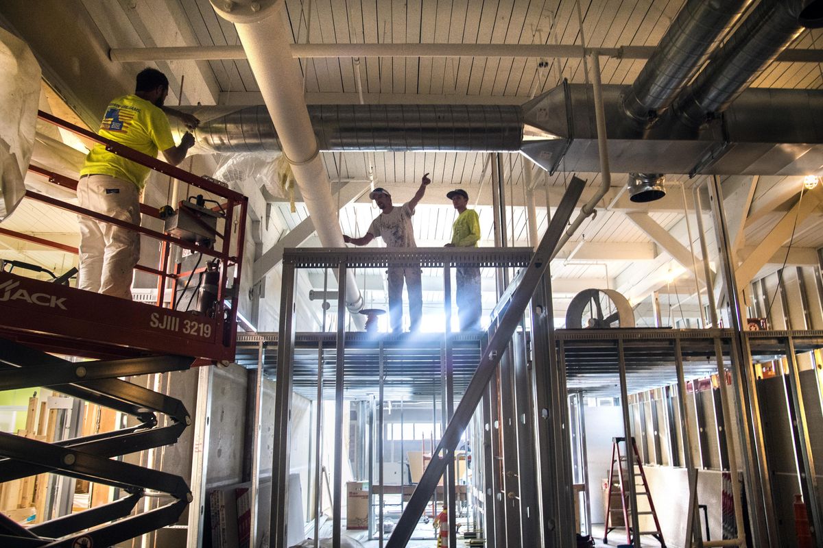 Painters Dan Hixon, left, James Dixon and Ethan Reynolds, of Steinco Construction, discuss their work around the sprinkler systems above the kitchen area at the new Prep Pride High School, Aug. 10, 2017, in Spokane, Wash. (Dan Pelle / The Spokesman-Review)