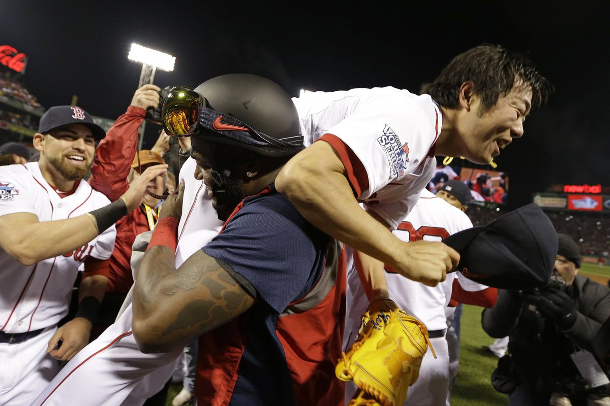 Boston slugger and MVP David Ortiz hoists closer Koji Uehara after Red Sox defeated St. Louis to clinch World Series title on home soil for first time since 1918. (ASSOCIATED PRESS)