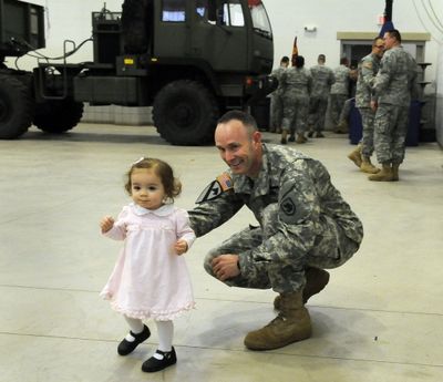 Washington Army National Guard SFC Dean Smith shares a last few moments with his 1 year-old daughter Molly before a farewell ceremony at the the National Guard Readiness Center on Saturday. (Dan Pelle / The Spokesman-Review)