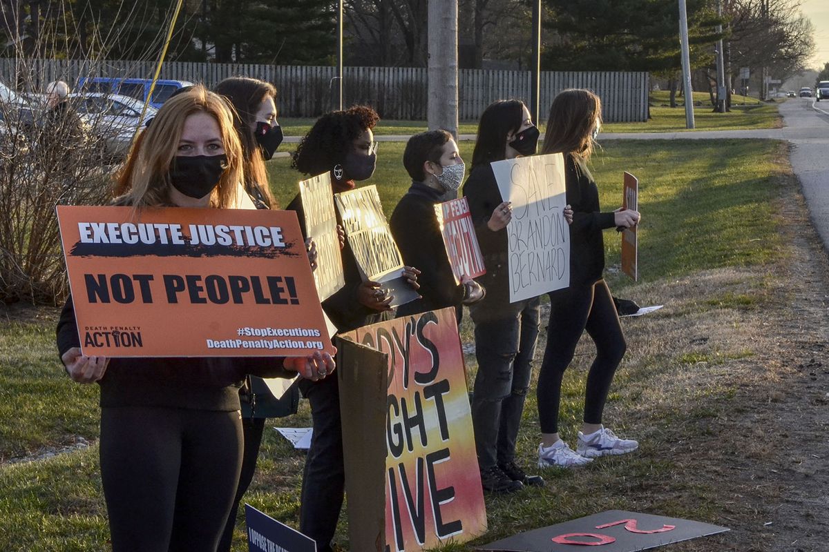 Protesters line Prairieton Road across from the Federal Execution Chamber, Thursday, Dec. 10, 2020 in Terre Haute, Ind. The execution Brandon Bernard, convicted in the 1999 killing of two youth ministers in Texas is scheduled Thursday at the federal prison in Terre Haute, Indiana..  (Austen Leake)