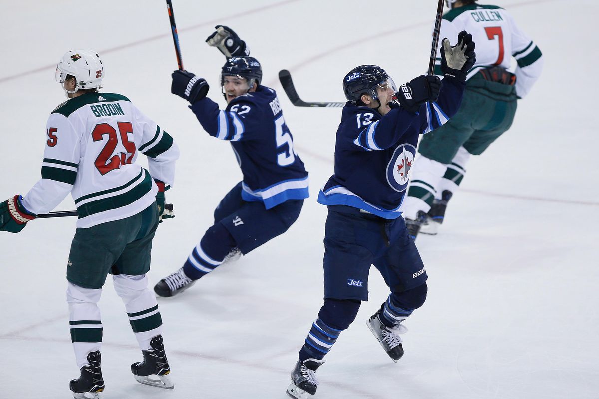 Winnipeg Jets’ Jack Roslovic (52) and Brandon Tanev (13) celebrate Tanev’s goal, as Minnesota Wild’s Jonas Brodin (25) and Matt Cullen (7) turn away during the first period in Game 5 of an NHL hockey first-round playoff series in Winnipeg, Manitoba, Friday, April 20, 2018. (John Woods / Canadian Press via AP)