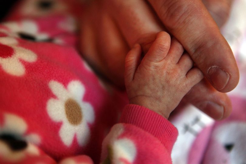 Newborn Avery Luaces holds her father Dave Luaces’ thumb in their Grayslake, Ill., home.