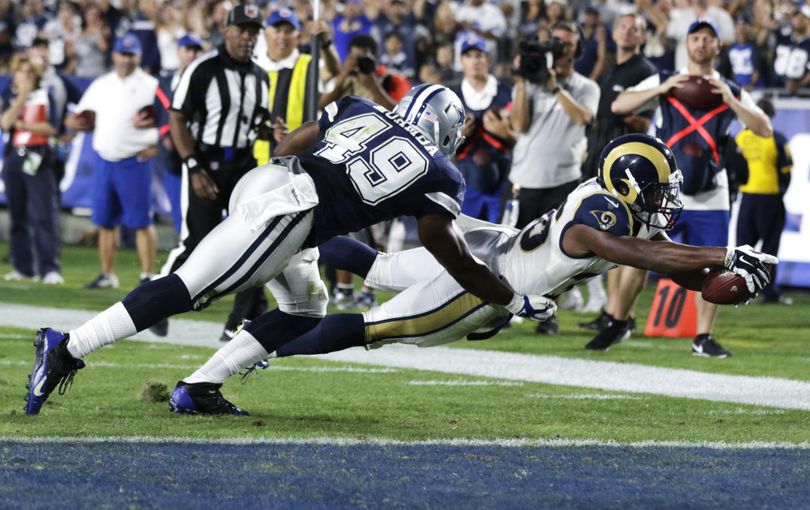 Los Angeles Rams running back Aaron Green, right, dives into the end zone ahead of Dallas Cowboys linebacker Henoc Muamba to score the winning touchdown Saturday. (Ryan Kang / Associated Press)