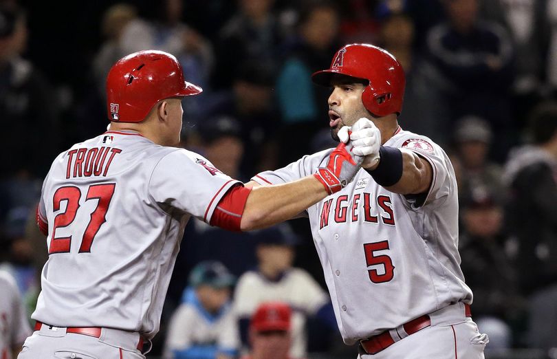 Los Angeles Angels’ Albert Pujols, right, is greeted at home by Mike Trout after Pujols’ three-run home run in the ninth inning. (Elaine Thompson / Associated Press)