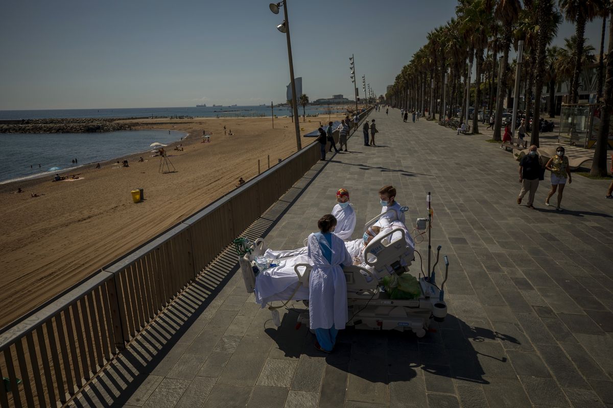 Francisco Espana, 60, is surrounded by members of his medical team Sept. 4 as he looks at the Mediterranean sea from a promenade next to the “Hospital del Mar” in Barcelona, Spain. Francisco spent 52 days in the Intensive Care unit at the hospital due to coronavirus, but this day he was allowed by his doctors to spend almost 10 minutes at the seaside as part of his recovery therapy.  (Emilio Morenatti)