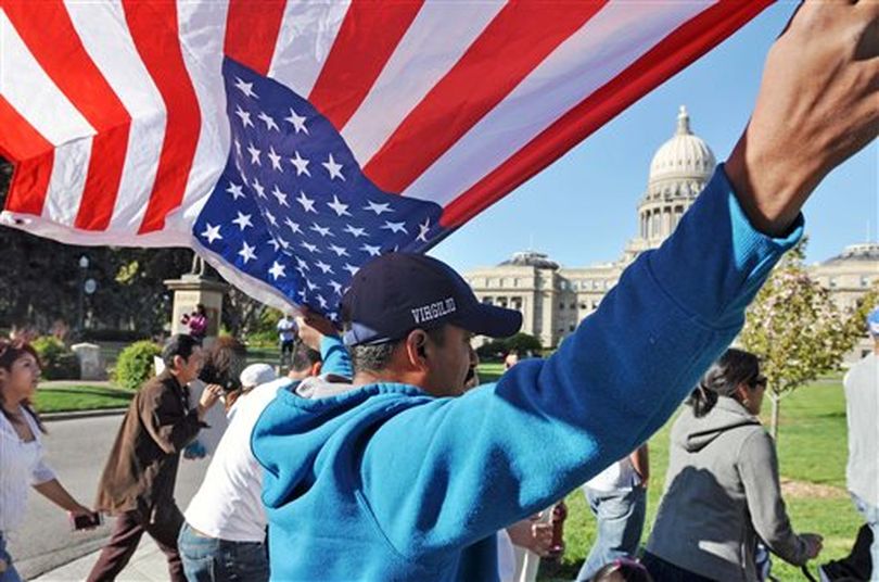 Virgilio Medina, of Nampa, Idaho, holds an American flag as he marches towards the Idaho Statehouse during the Family Unity Rally in support of immigrant rights, Wednesday May 1, 2013 in Boise, Idaho. (AP/Idaho Press-Tribune / Greg Kreller)