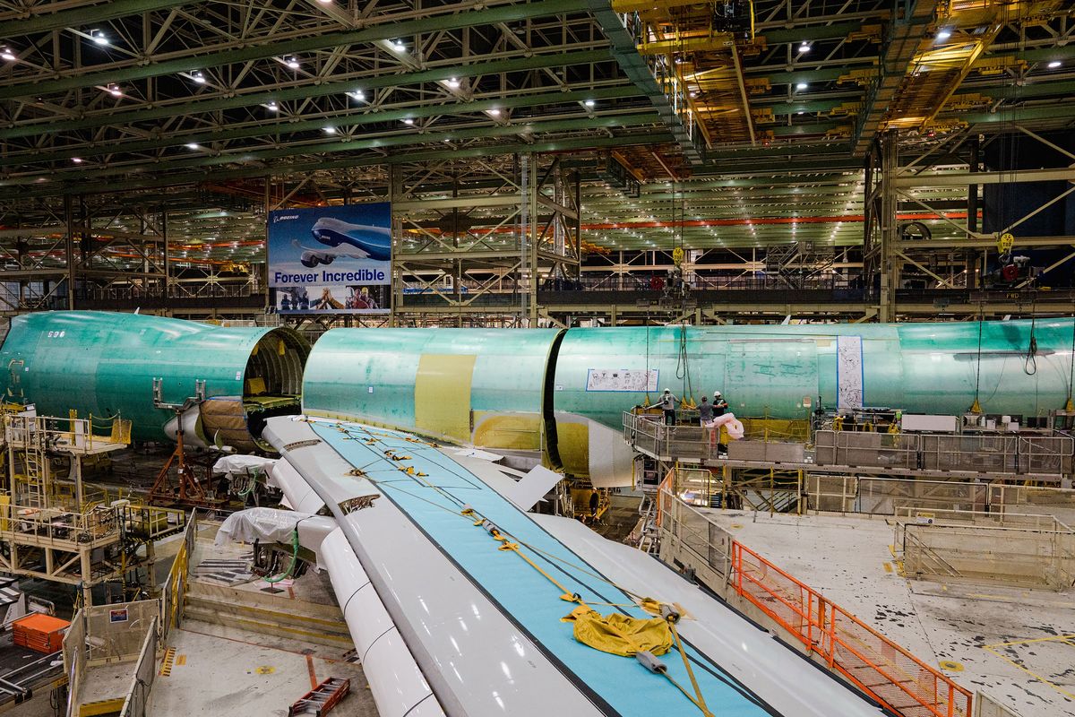 Cranes lift the rear fuselage into position during the final body join of the last 747 jumbo jet at the Boeing factory in Everett on Sept. 28. 2022.  (JOVELLE TAMAYO/THE NEW YORK TIMES)