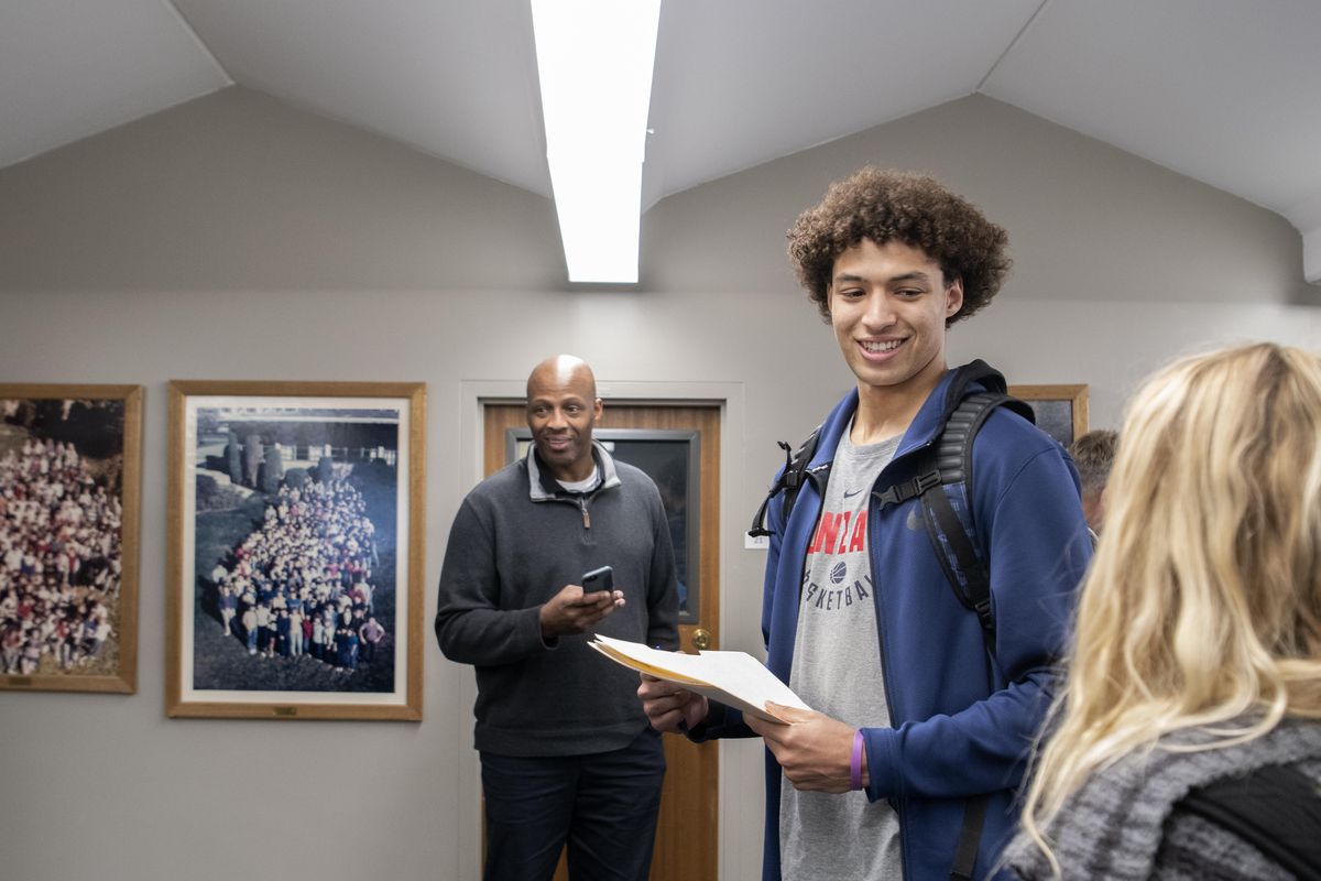 Gonzaga Prep basketball player Anton Watson chats with friends on Wednesday at G-Prep while waiting to sign his National Letter of Intent to attend Gonzaga University. Behind him is his father Deon Watson, a former Idaho basketball player. (Jesse Tinsley / The Spokesman-Review)