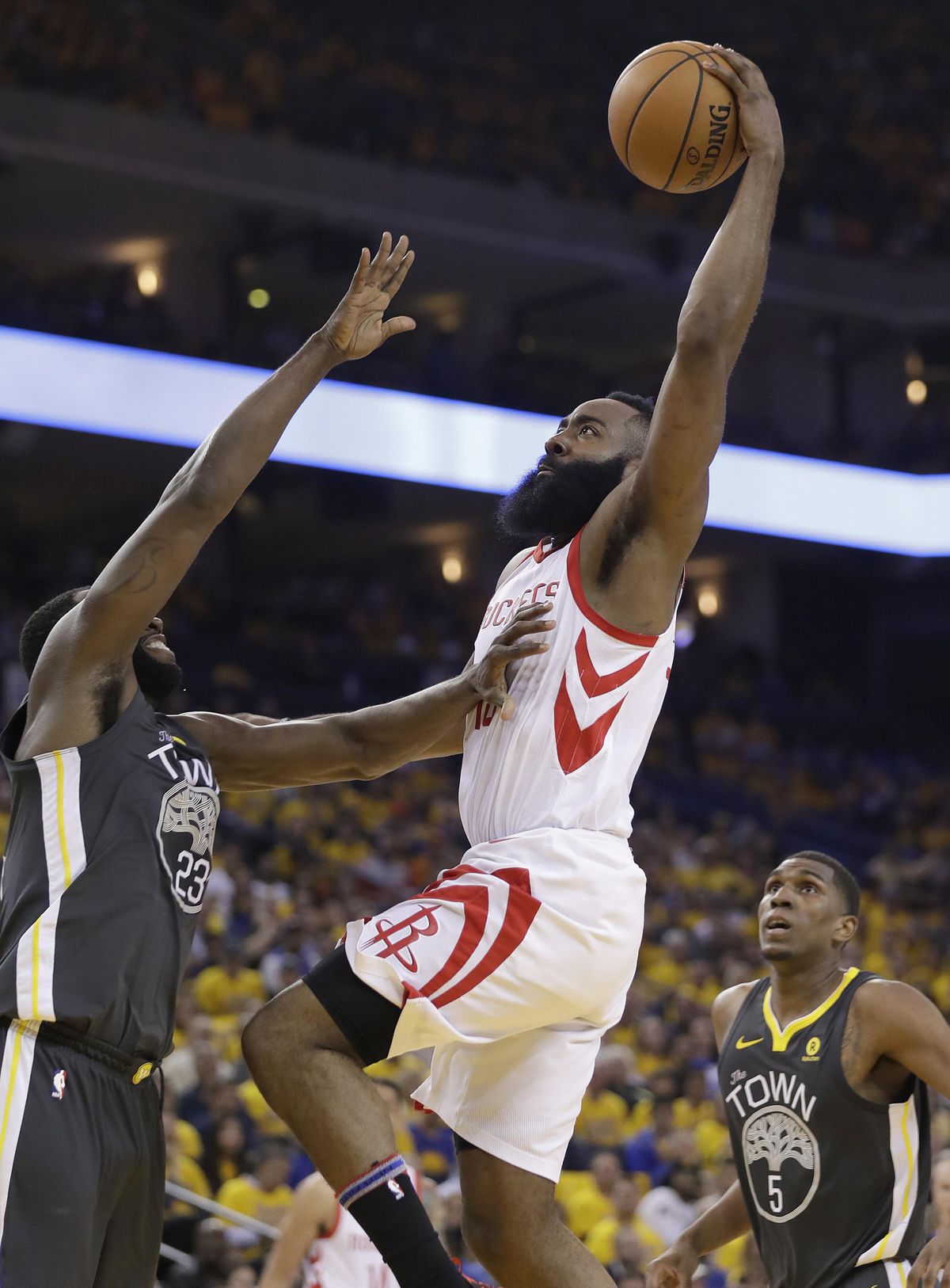 Houston Rockets guard James Harden, center, dunks against Golden State Warriors forward Draymond Green, left, and forward Kevon Looney (5) during the first half of Game 4 of the NBA basketball Western Conference Finals in Oakland, Calif., Tuesday, May 22, 2018. (AP Photo/Marcio Jose Sanchez) ORG XMIT: OAS122 (Marcio Jose Sanchez / AP)