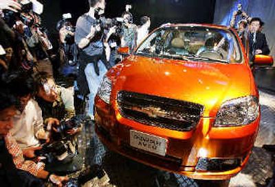 
Chinese journalists take photographs of a new model of General Motors Chevrolet Aveo in April.  
 (Associated Press / The Spokesman-Review)