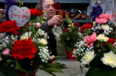 Cindy Williams puts the finishing touches on a Valentine's Day arrangement at Roses and More. 
 (Photos by Jed Conklin/ / The Spokesman-Review)