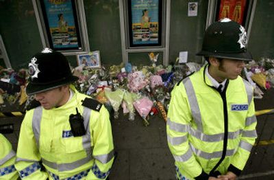 
Police officers stand by the floral tributes left outside Kings Cross Station in London on Saturday as people pay their respects following Thursday's bombings. 
 (Associated Press / The Spokesman-Review)