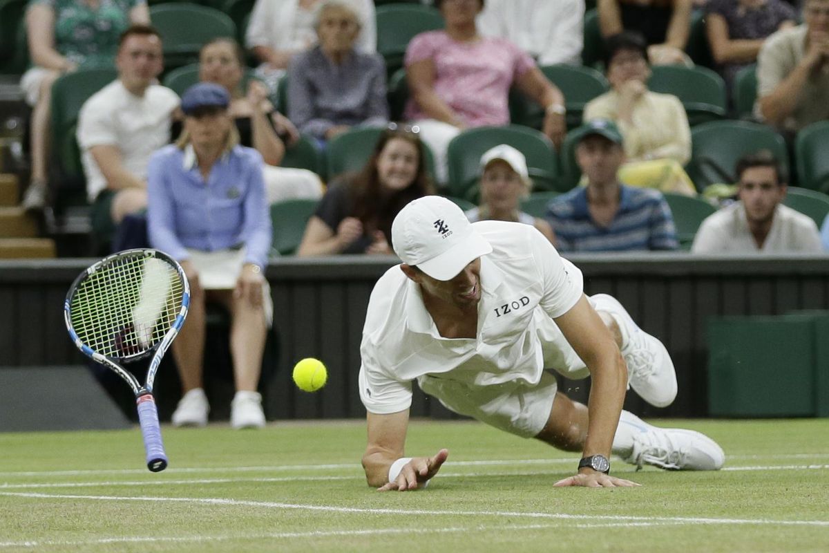 Mike Bryan of the United States falls trying to return a shot during his and his partner Jack Sock’s men’s doubles final match against South Africa’s Raven Klaasen and New Zealand’s Michael Venus at the Wimbledon Tennis Championships, in London, Saturday July 14, 2018. (Tim Ireland / Associated Press)