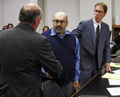 
Naveed Haq, center, shakes hands with his attorney, C. Wesley Richards, left, after the mistrial was declared.
 (The Spokesman-Review)