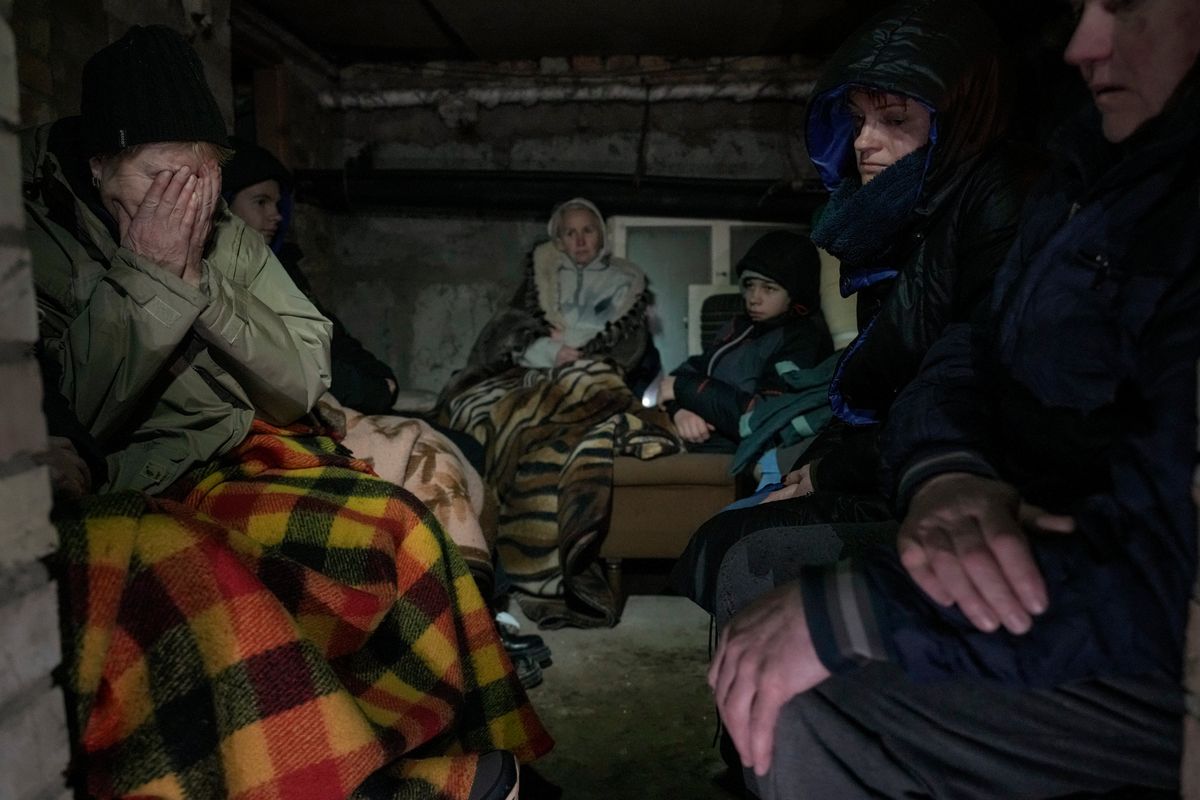 A woman cries in the small basement of a house crowded with people seeking shelter from Russian airstrikes, outside the capital Kyiv, Ukraine, Wednesday, March 2, 2022. Russia renewed its assault on Ukraine