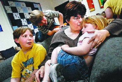 Linda Baker, mother of six, kisses her daughter Ailish, 4, while sons Ben, 11, left, and Andrew, 7, watch. Baker fled an abusive spouse and sought help through the YWCA.
(Brian Plonka / The Spokesman-Review)