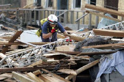 A FEMA search and rescue task force member looks on Wednesday for victims of Hurricane Katrina in a storm-damaged building in Waveband, Miss. Unsanitary conditions are spreading across areas of the Gulf Coast devastated by the storm.
 (Associated Press / The Spokesman-Review)