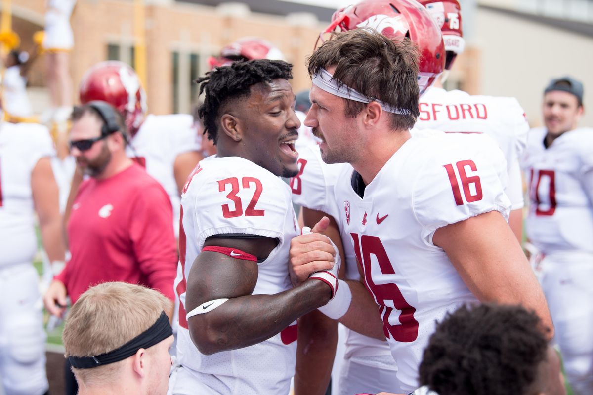 Washington State quarterback Gardner Minshew (16) celebrates with  running back James Williams  after they connected for a touchdown against Wyoming on Sept. 1  at War Memorial Stadium in Laramie, Wyo. (Tyler Tjomsland / The Spokesman-Review)