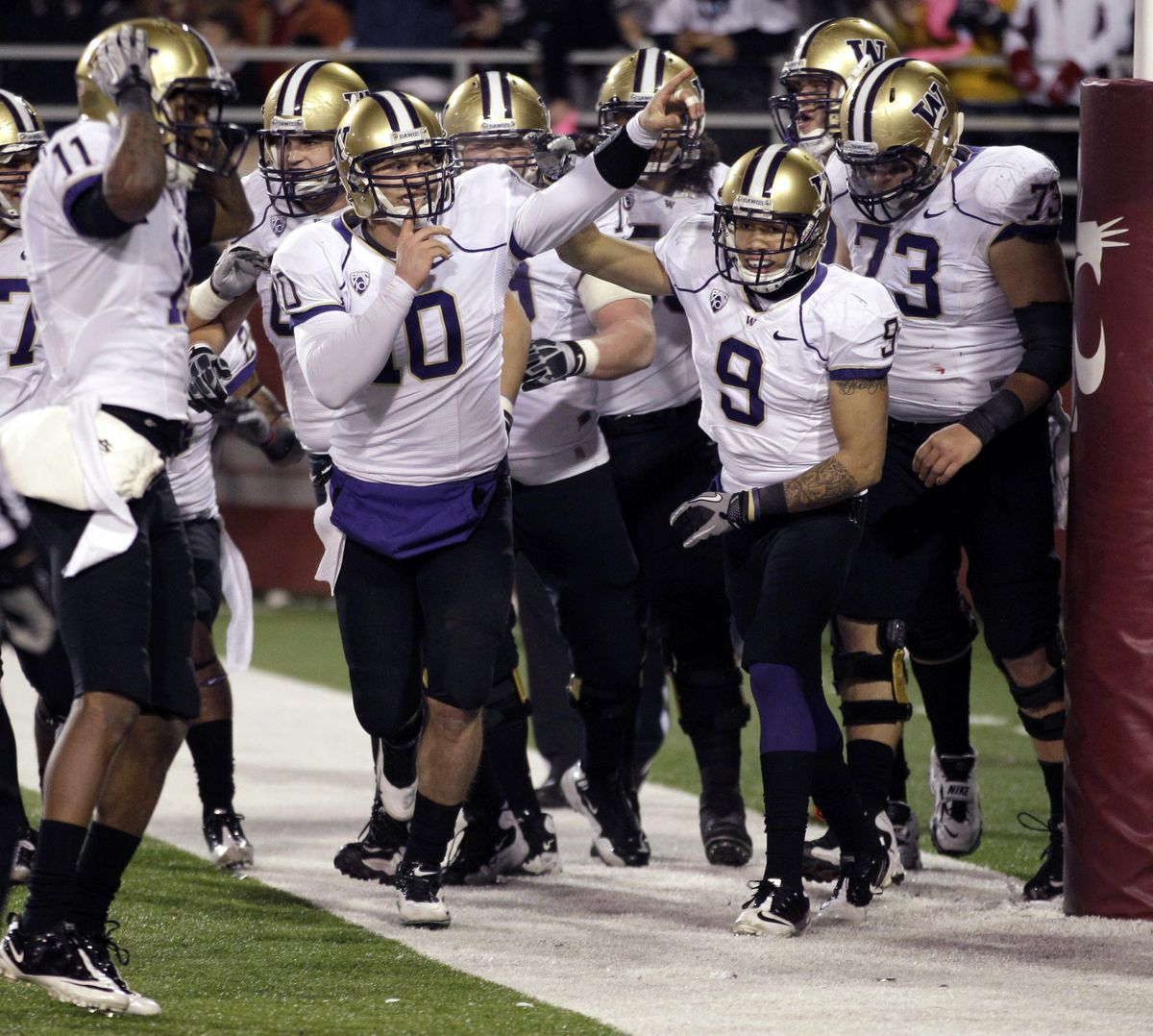 Washington quarterback Jake Locker (10) celebrates with his team after he ran for a touchdown against Washington State in the first half of the Apple Cup.  (Ted Warren / Associated Press)