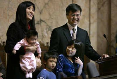 
Gov. Gary Locke, right, smiles as he stands with his family during his final State of the State address Tuesday in Olympia. With Locke are his wife, Mona, holding daughter Madeline, son Dylan and daughter Emily.
 (Associated Press / The Spokesman-Review)