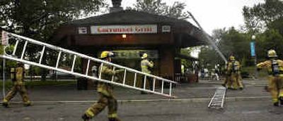 
Firefighters hustle to the roof of the smoke-filled Carrousel Grill on Saturday where they concentrated efforts on removing a section of the chimney. Firefighters hustle to the roof of the smoke-filled Carrousel Grill on Saturday where they concentrated efforts on removing a section of the chimney. 
 (Jed Conklin/Jed Conklin/ / The Spokesman-Review)