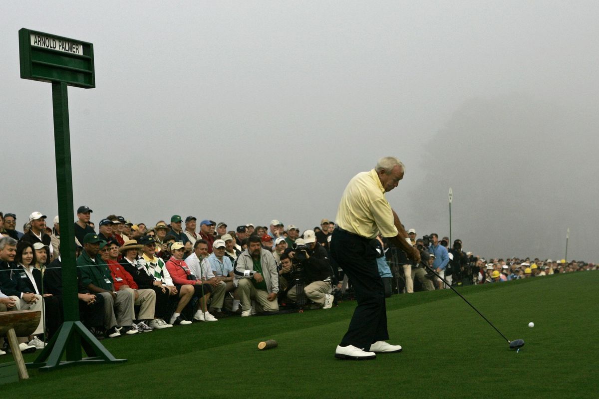 Golfing legend Arnold Palmer, right, signs the back of fellow