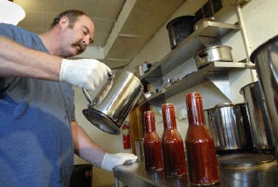 
Randy Mace of B & R Creations in Davenport, Washington, fills bottles by hand with BJ's All American Home Style B.B.Q Sauce in the Community Center kitchen.
 (Dan Pelle / The Spokesman-Review)
