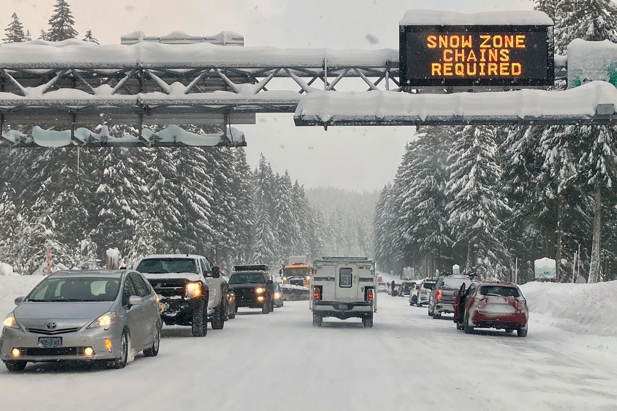 Heavy traffic is seen at the base of a snowy Santiam Pass in Detroit, Ore., Sunday, Dec. 26, 2021. Emergency warming shelters were opened throughout western Washington and Oregon as temperatures plunged into the teens and lower and forecasters said the arctic blast would last for several days.  (Andrew Selsky)