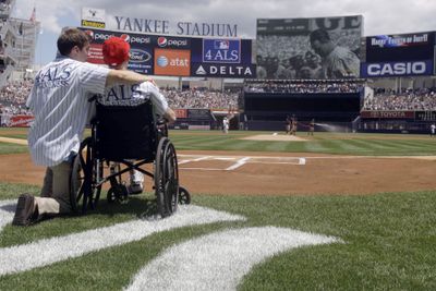 Michael Goldsmith, right, who suffers from ALS, and his son Austin take part in Lou Gehrig Appreciation Day.  (Associated Press / The Spokesman-Review)