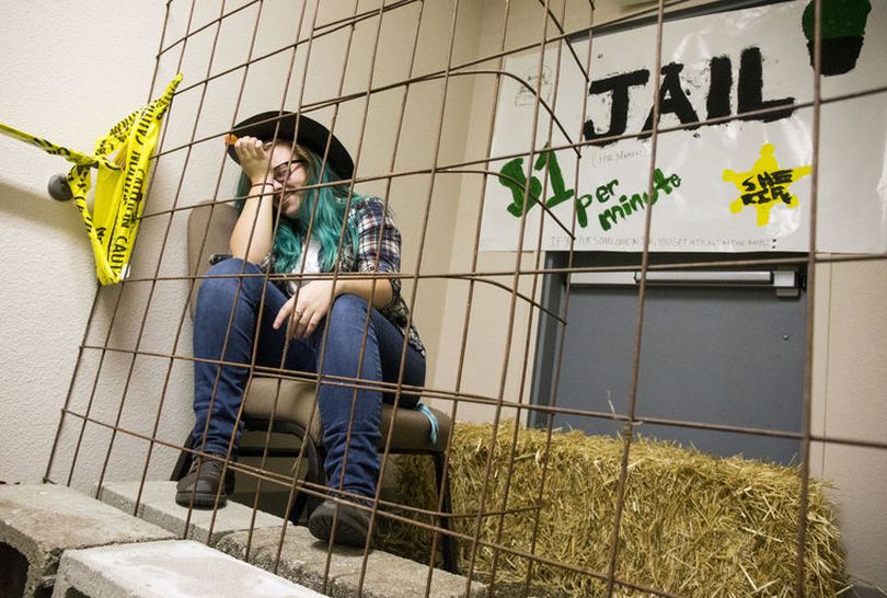 Nimue Frye sits in the jail thanks to her friend Elizabeth Ryssel who paid $7 to put her in jail for seven minutes during Prairie Community Church's Harvest Party on Friday. (Loren Benoit/Coeur d'Alene Press photo)