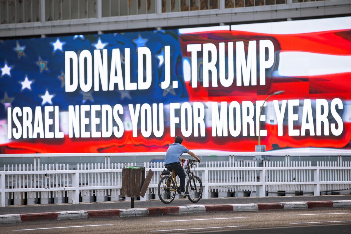 FILE - In this Oct. 21, 2020 file photo a cyclist rides next to a billboard supporting President Donald Trump, ahed of the U.S presidential election, in Tel Aviv, Israel. Tuesday