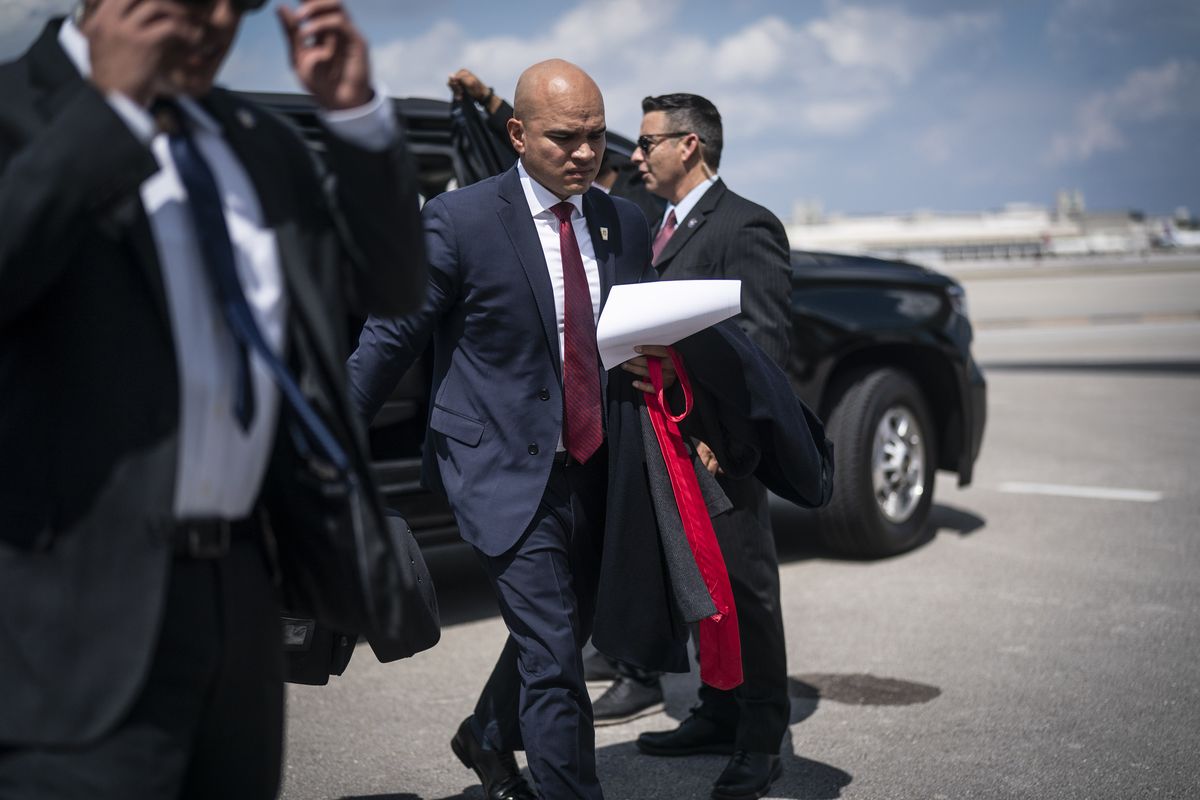 Walt Nauta, an aide to Donald Trump, follows the former president as they board his airplane en route to Iowa at Palm Beach International Airport in Florida in March.    (Jabin Botsford/The Washington Post)