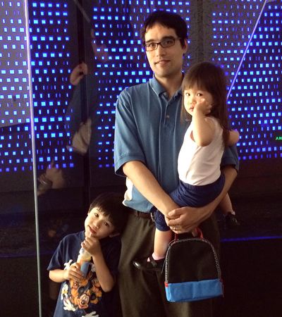 Robert Dirks poses with his son, Owen, and daughter, Phoebe, in front of a supercomputer in spring 2014.