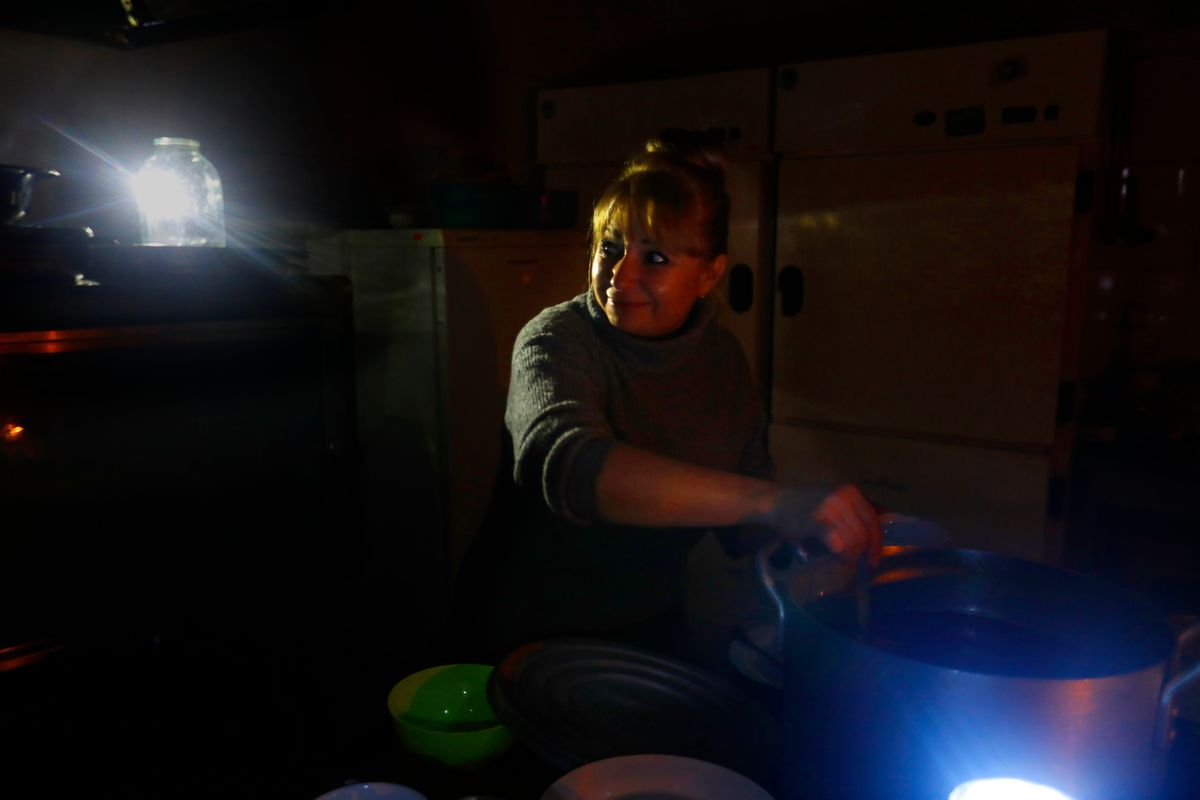 Nataliya Bautina, of Donetsk, Ukraine, cooks by candlelight at Helicon Hotel after the electricity went out Saturday.  (Carolyn Cole/Los Angeles Times/TNS)