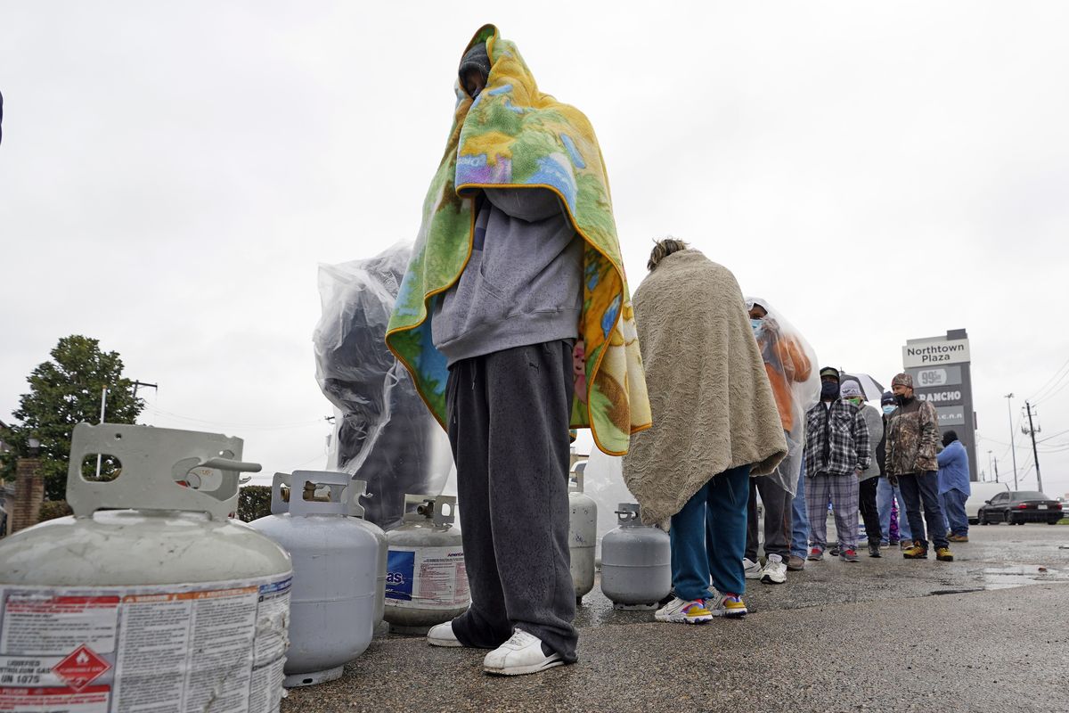 Carlos Mandez waits in line to fill his propane tanks Wednesday, Feb. 17, 2021, in Houston. Customers had to wait over an hour in the freezing rain to fill their tanks. Millions in Texas still had no power after a historic snowfall and single-digit temperatures created a surge of demand for electricity to warm up homes unaccustomed to such extreme lows, buckling the state