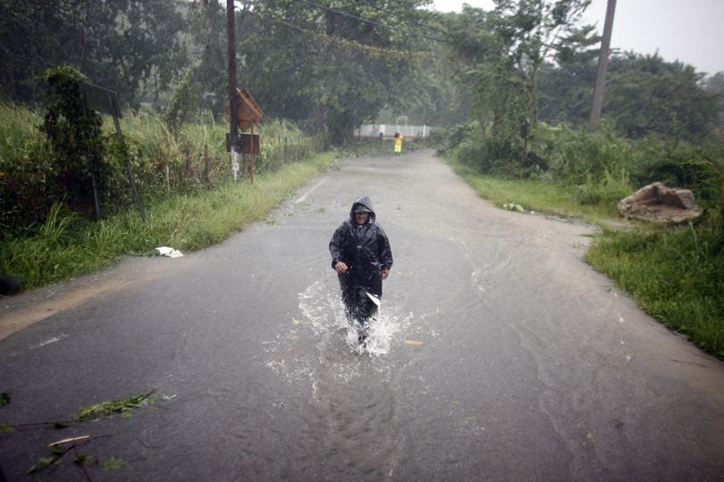 A man wades through a flooded street after Hurricane Irene hit the area of Naguabo, Puerto Rico, on Monday. Irene could reach the U.S. mainland by the end of the week. (Associated Press)