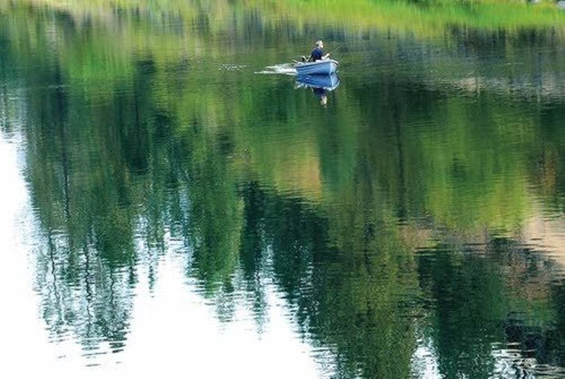 A fisherman gets in some quiet angling on a calm stretch of the Clearwater River above Orofino. (Barry Kough / Lewiston Tribune)