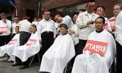 
Members of the Jellanamdo Provincial Assembly have their heads shaved by colleagues Tuesday during an anti-government rally against U.S. imported beef in Seoul. Associated Press
 (Associated Press / The Spokesman-Review)