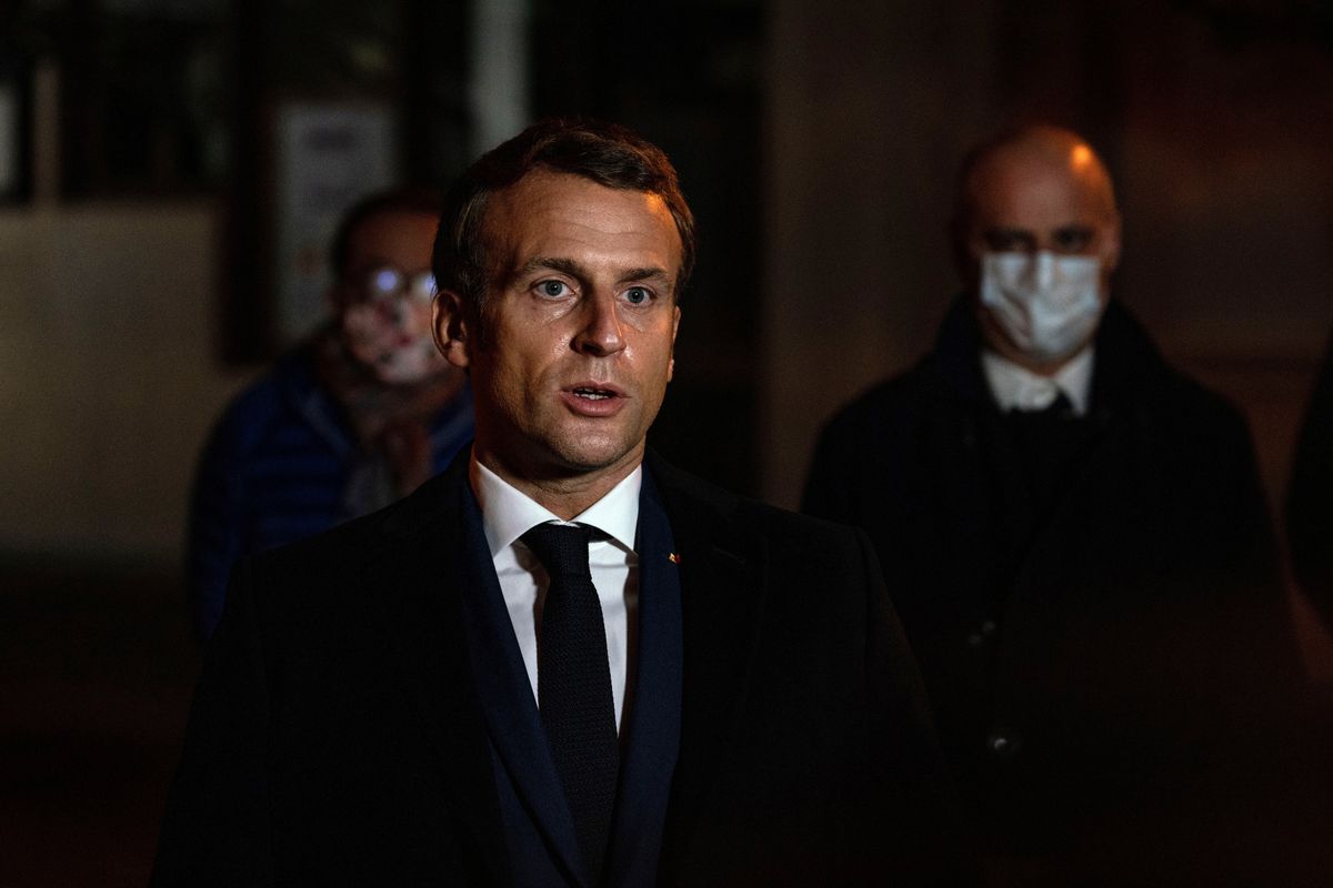 French President Emmanuel Macron speaks in front of a high school Friday Oct.16, 2020 in Conflans Sainte-Honorine, northwest of Paris, where a history teacher who opened a discussion with high school students on caricatures of Islam
