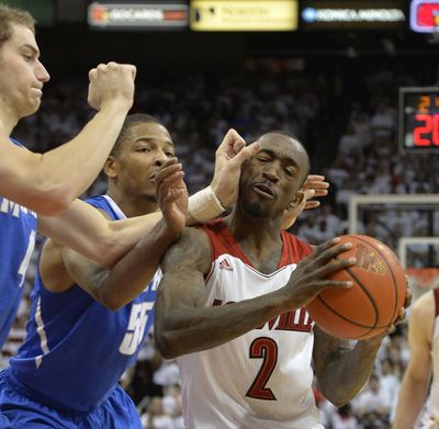 Louisville guard Russ Smith, right, gets trapped by Memphis' Austin Nichols, left, and Geron Johnson during the second half. (Associated Press)