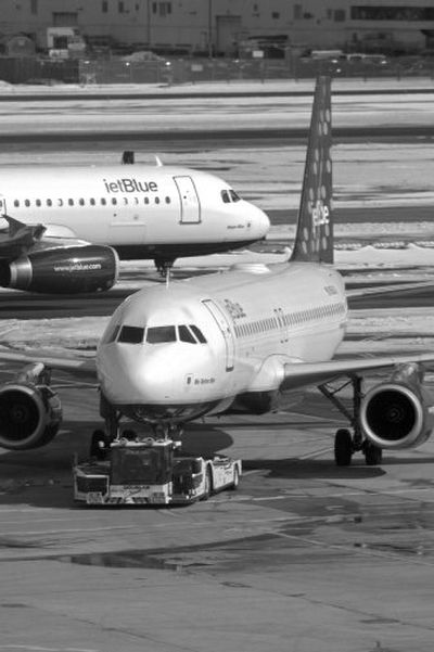 
A JetBlue Airbus A320 taxis past another plane being towed to a gate Sunday at JFK International Airport in New York. 
 (Associated Press / The Spokesman-Review)