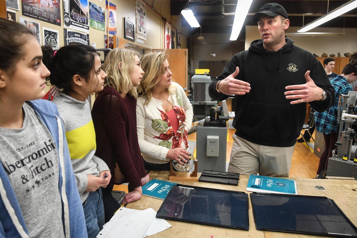 Sacajawea Middle School students, from left, Hallie Brigham, Sarah Hedge, Joanna Glanville and teacher Kim Taylor talk Thursday, Jan. 10, 2019 with Spokane police Officer and Bomb Squad member Toby Bryer about designing holding pieces for X-ray equipment for the bomb squad robot. (Dan Pelle / The Spokesman-Review)