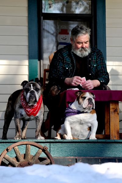 Porch pooches: “They’re like an old married couple,” said Jim Ackerman about his bulldogs, Buster, left, and Beulah, while playing solitaire on his front porch in Coeur d’Alene on Monday. (Kathy Plonka)