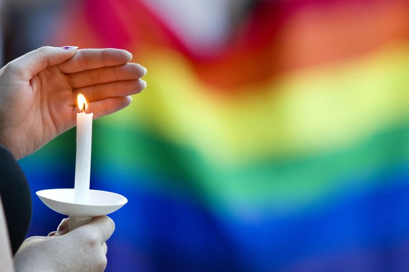 A candle burns in front of a pride flag while community members gather for a vigil to honor the victims of the attack on a nightclub in Orlando, Florida, on Sunday at Friendship Square in Moscow, Idaho. More than 150 people attended the vigil. (Geoff Crimmins / AP)